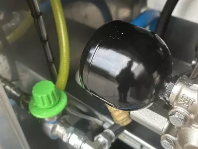 Pressure accumulator and low-pressure chemical injector installed on a Nilfisk 400HS DTE system. The accumulator smooths pressure fluctuations for a steadier flow, while the injector allows efficient low-pressure chemical application for pre-soaking and f